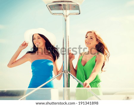 summer holidays and vacation concept - girls on boat or yacht