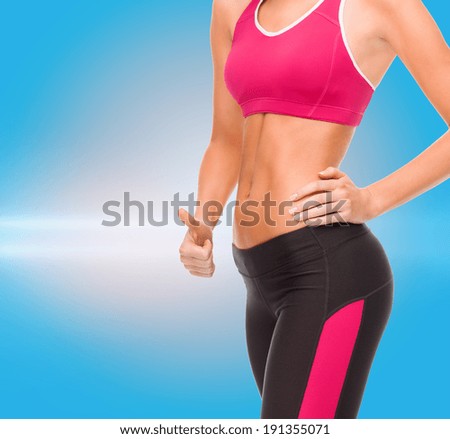 fitness and diet concept - close up of female abs and hand showing thumbs up