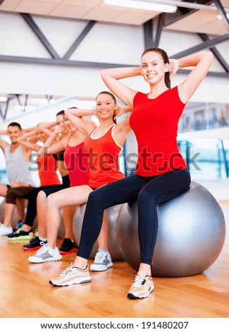fitness, sport, training, gym and lifestyle concept - group of smiling people working out in pilates class