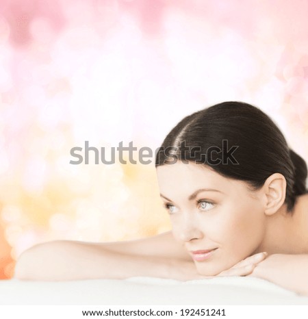 spa, vacation and resort concept - smiling woman in spa salon lying on the massage desk