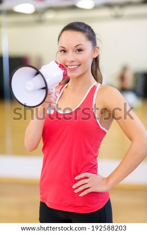 fitness, sport, training, gym and lifestyle concept - beautiful sporty woman with megaphone at gym