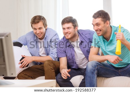 friendship, sports and entertainment concept - happy male friends with football and vuvuzela supporting football team at home
