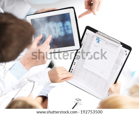 healthcare, hospital and medical concept - group of doctors looking at x-ray on tablet pc