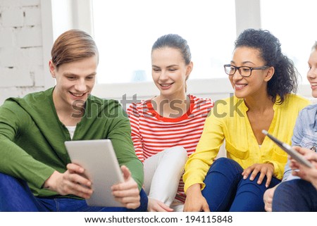 education and technology concept - smiling students with tablet pc computer at home
