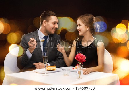 restaurant couple and holiday concept smiling couple eating dessert at restaurant restaurant couple and holiday concept smiling couple eating dessert at restaurant