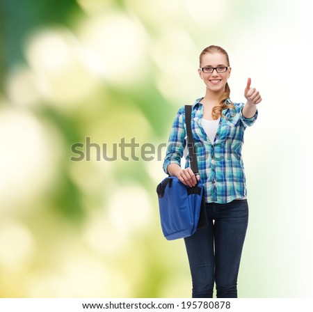 education and people concept - smiling female student in eyeglasses with laptop bag showing thumbs up over green background