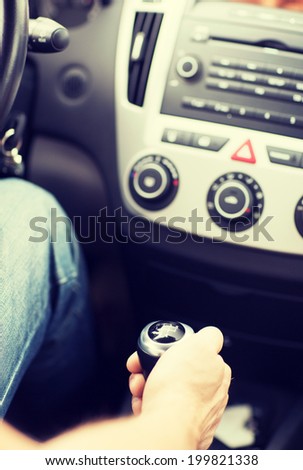 transportation and vehicle concept - man shifting the gear on car manual gearbox