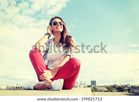 summer holidays and teenage concept - smiling teenage girl in sunglasses with headphones outdoors