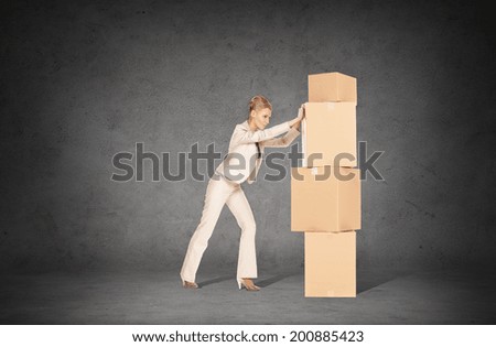 business, postal and office concept - businesswoman pushing tower of cardboard boxes