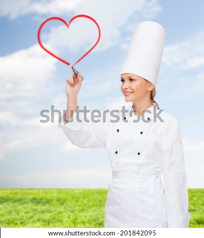 cooking, new technology , advertisement and food concept - smiling female chef with marker drawing red heart on virtual screen