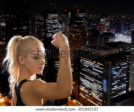 fitness and diet concept - close up of beautiful athletic woman flexing her biceps