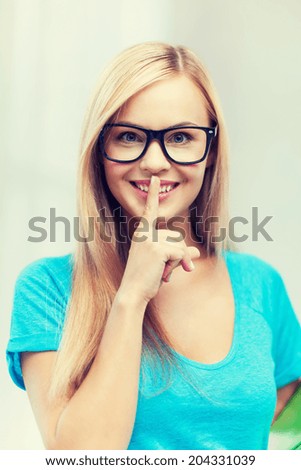 picture of smiling woman with finger on her lips