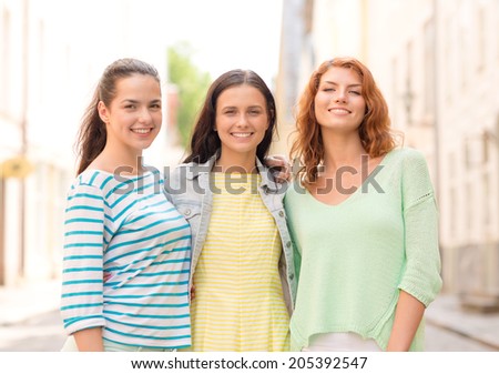 vacation, weekend, leisure and friendship concept - smiling teenage girls on street