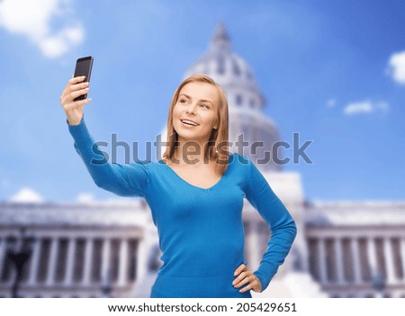 technology, travel and internet concept - smiling woman taking self picture with smartphone camera
