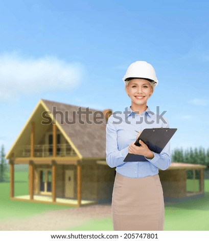 building, developing, construction and architecture concept - smiling businesswoman in white helmet with clipboard
