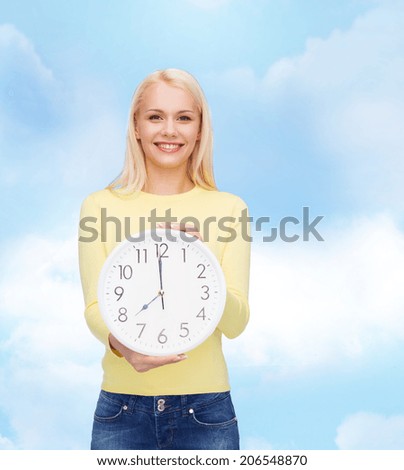 time, education and people concept - smiling young woman with wall clock showing 8