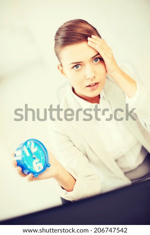 business and time management concept - stressed businesswoman holding clock