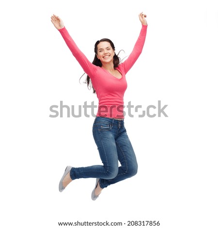 happiness, freedom, movement and people concept - smiling young woman jumping in air