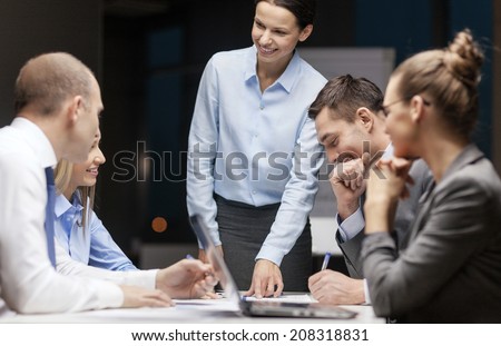 business, technology and office concept - smiling female boss talking to business team