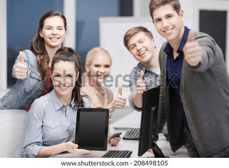 education, advertisement, techology and internet concept - group of smiling students with computer monitor and blank black tablet pc screen