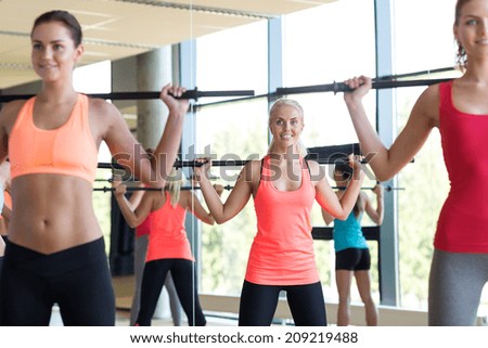 fitness, sport, training, gym and lifestyle concept - group of women with bars in gym