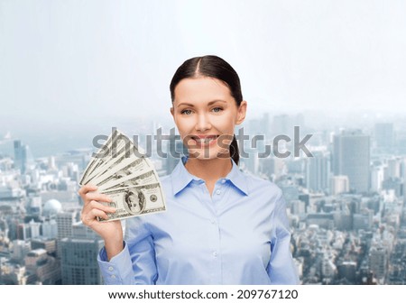 business and money concept - young businesswoman with dollar cash money over cityscape background