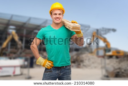 building, repair, construction and maintenance concept - smiling male manual worker in protective helmet carrying wooden boards