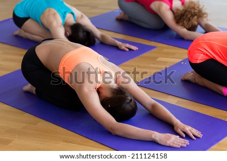 fitness, sport, training and lifestyle concept - group of women stretching in gym