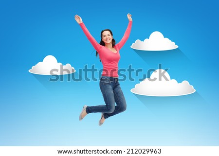 happiness, freedom, movement and people concept - smiling young woman jumping in air over blue sky with white clouds background
