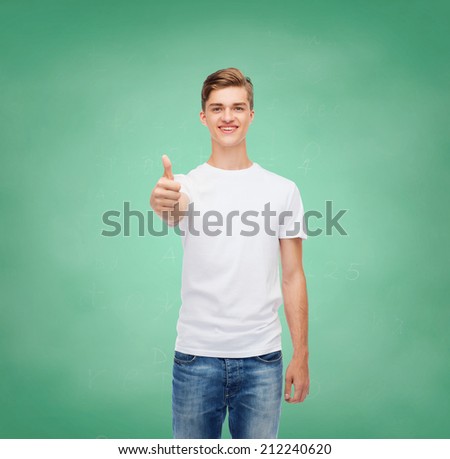 gesture, advertising, education, school and people concept - smiling young man in blank white t-shirt showing thumbs up over green board background
