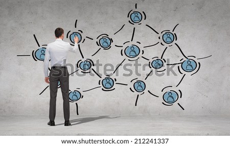 business, education and office people concept - businessman or teacher with marker drawing scheme from back over concrete wall background