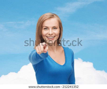 gesture and people concept - smiling student pointing finger at you