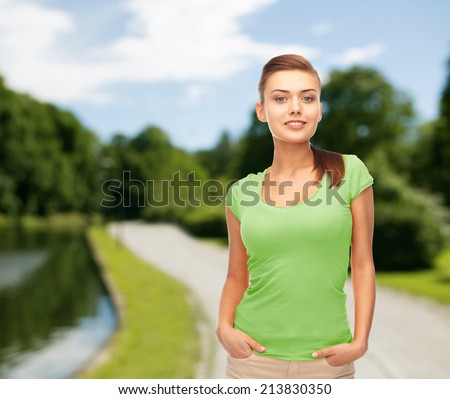 t-shirt design, leisure and people concept - smiling young woman in blank green t-shirt