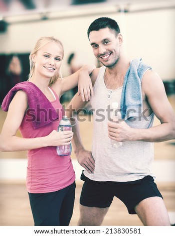fitness, sport, training, gym and lifestyle concept - two smiling people in the gym