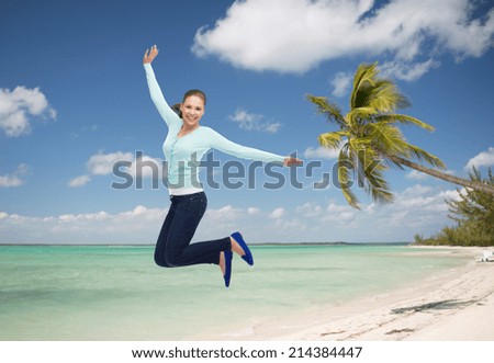 summer vacation, travel, tourism, freedom and people concept - smiling young woman jumping in air over tropical beach background