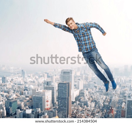 happiness, freedom, movement and people concept - smiling young man flying in air over city background