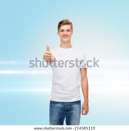 gesture, advertising and people concept - smiling young man in blank white t-shirt showing thumbs up over blue laser background
