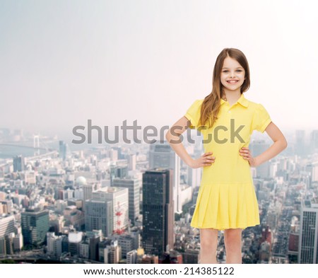 happiness, childhood and people concept - smiling little girl in yellow dress