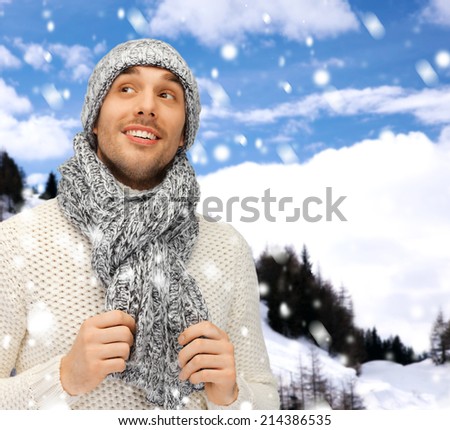 winter holidays, vacation and lifestyle concept - handsome man in warm sweater, hat and scarf