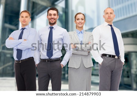 business, partnership and people concept - group of smiling businessmen over business center background