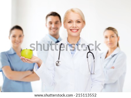 healthcare and medicine concept - smiling female doctor with stethoscope and green apple