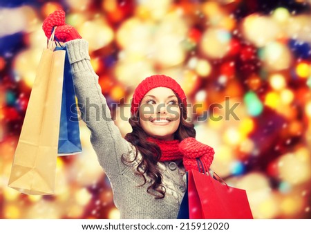 shopping, christmas sale and gifts concept - happy asian woman in winter clothes with shopping bags