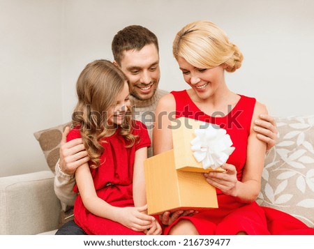 family, christmas, happiness and people concept - happy family opening gift box
