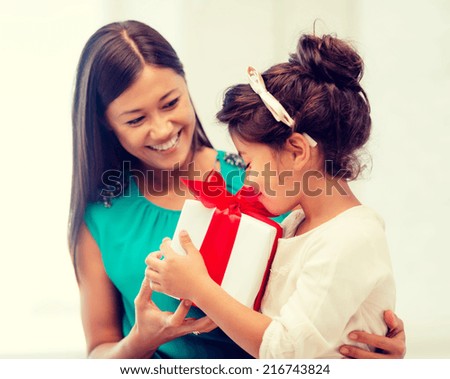 holidays, presents, christmas, x-mas and birthday concept - happy mother and child girl with gift box