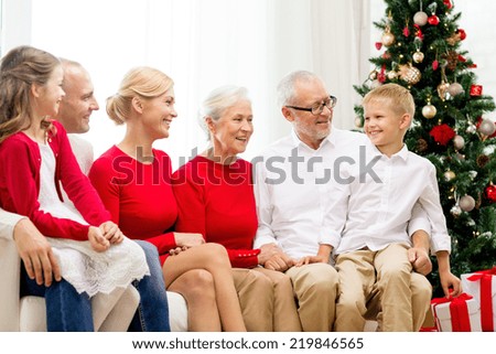 family, holidays, generation, christmas and people concept - smiling family sitting on couch at home