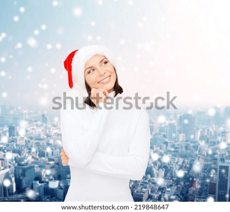 christmas, holidays, winter, happiness and people concept - thinking and smiling woman in santa helper hat over snowy city background
