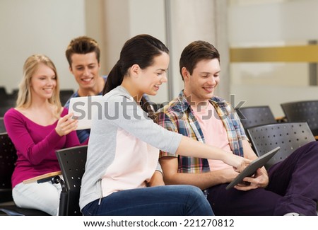education, high school, teamwork and people concept - group of smiling students with tablet pc computers sitting in lecture hall