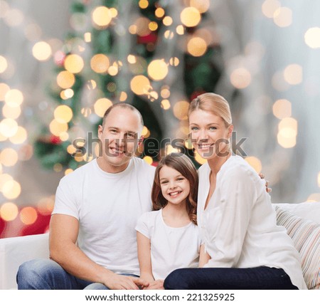 family, childhood, holidays and people - smiling mother, father and little girl over christmas tree lights background