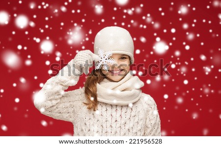 winter, people and happiness concept - smiling girl in hat, scarf and gloves with big snowflake