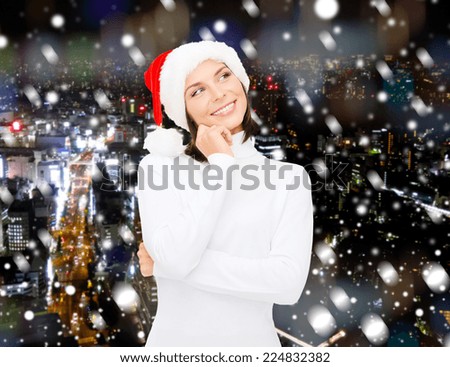 christmas, holidays, winter, happiness and people concept - thinking and smiling woman in santa helper hat over snowy night city background